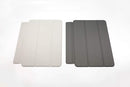 Left to right: Silver cover, space gray cover lying flat on white surface.